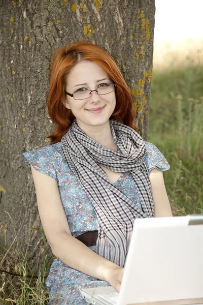 Giovane ragazza di moda in occhiali e notebook seduto vicino — Foto Stock