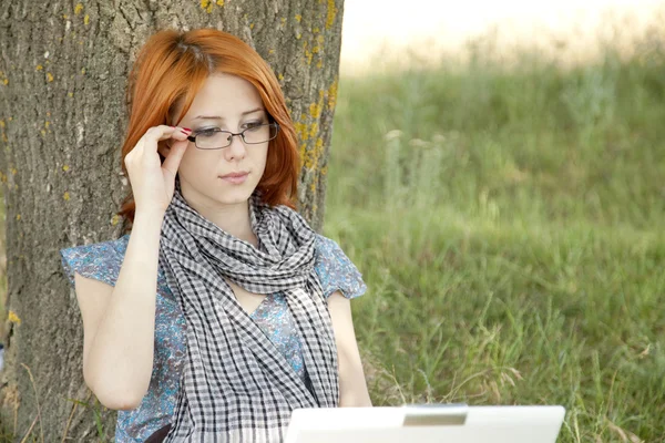 Giovane ragazza di moda in occhiali e notebook seduto vicino — Foto Stock