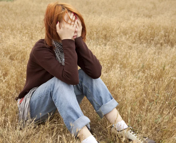 Osamělý smutný rusovlasá dívka na pole — Stock fotografie