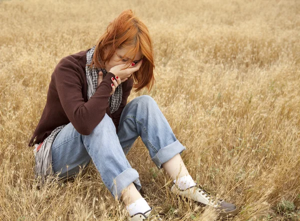 Lonely sad red-haired girl at field — Stock Photo, Image