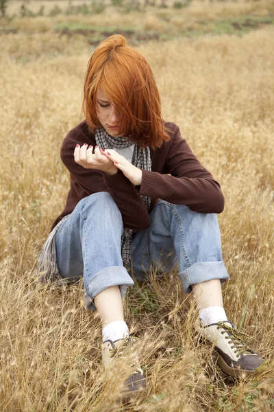 Samotny smutny rudowłosej dziewczyny w dziedzinie — Zdjęcie stockowe