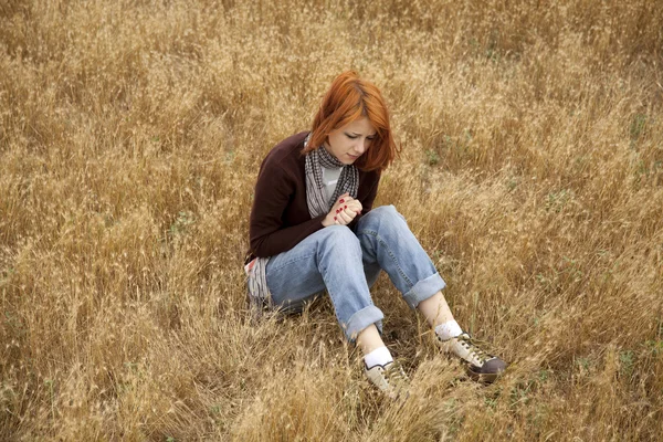 Lonely sad red-haired girl at field — Stock Photo, Image