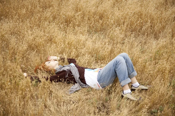 Jeune belle fille couchée au champ d'automne jaune . — Photo
