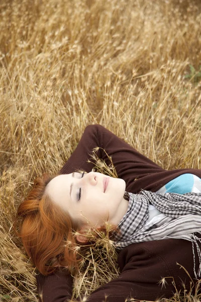 Молода красива дівчина лежить на жовтому осінньому полі . — стокове фото