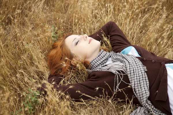 Młode piękne dziewczyny leżącej w żółtym polu jesień. — Zdjęcie stockowe