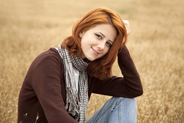 漂亮的红发女孩在黄色秋草. — 图库照片