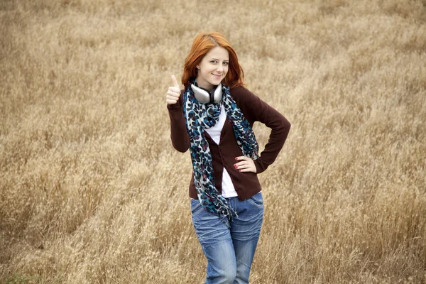 Moda joven sonriente con auriculares en el campo . — Foto de Stock