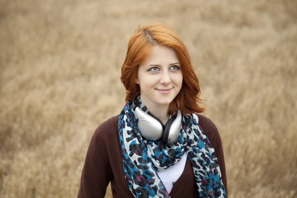Young smiling fashion with headphones at field. — Stock Photo, Image