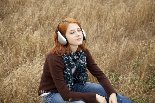 Moda joven sonriente con auriculares en el campo . —  Fotos de Stock