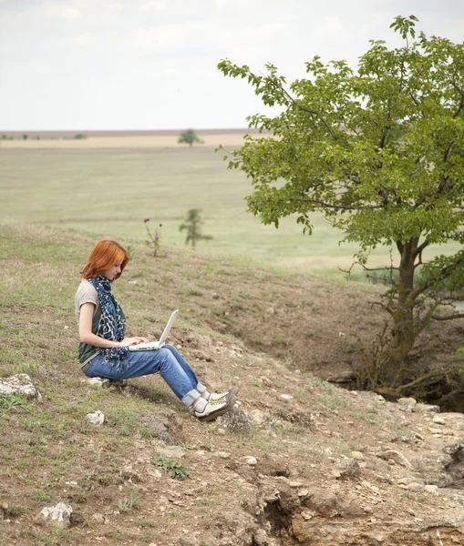 Genç güzel kız ile laptop Rock yakın göl ve ağaç. — Stok fotoğraf