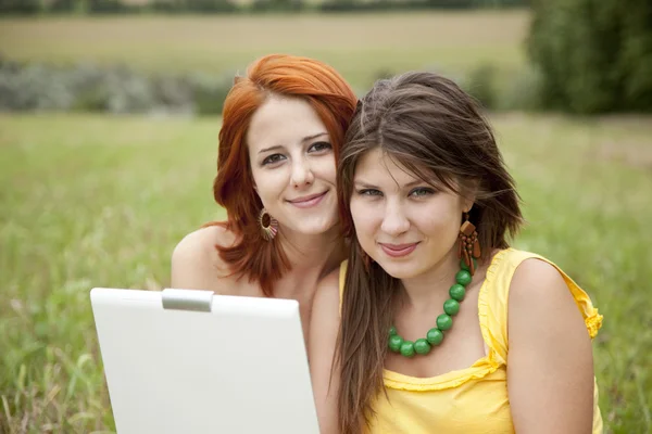 两个漂亮的女孩用的笔记本 免版税图库图片