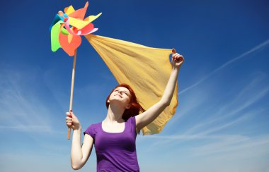 Young girl with wind turbine at rape field. clipart