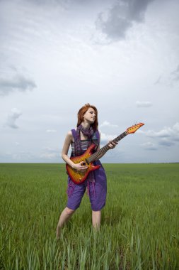 tulum gitar ile yeşil buğday alan kız.