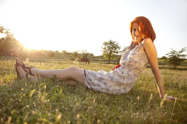 Menina no campo de grama verde ao pôr do sol . — Fotografia de Stock