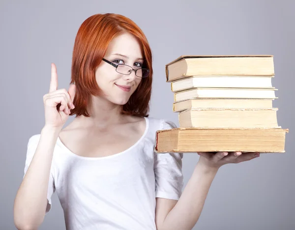 Rudowłosa kobieta uśmiechający się utrzymać książki w ręku. — Zdjęcie stockowe
