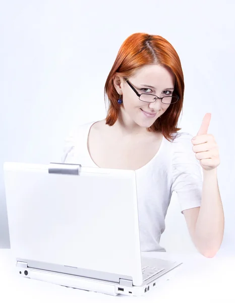 Rusovlasá dívka s bílým notebook Ukázat ok. Studio záběr. — Stock fotografie