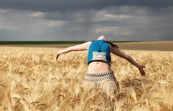 Mooi meisje op tarwe field in regenachtige dag — Stockfoto