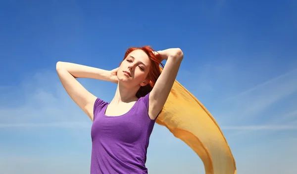 Mladá žena s otevřenou náručí udržet žluté hedvábí na vítr. — Stock fotografie