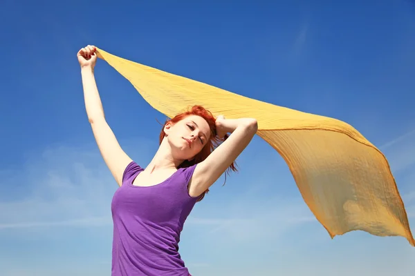 Giovane donna a braccia aperte mantenere la seta gialla sul vento . — Foto Stock