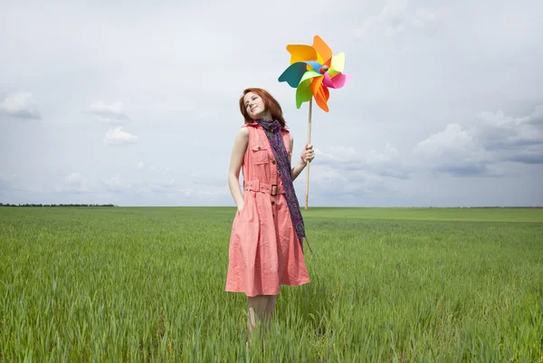 Κορίτσι στο πεδίο πράσινο σιτάρι με ανεμογεννήτρια — Φωτογραφία Αρχείου