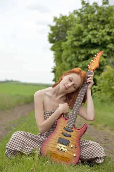 Девушка с гитарой на деревенской дороге — стоковое фото