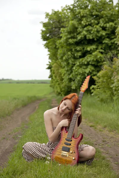 Дівчина з гітарою на сільській дорозі — стокове фото