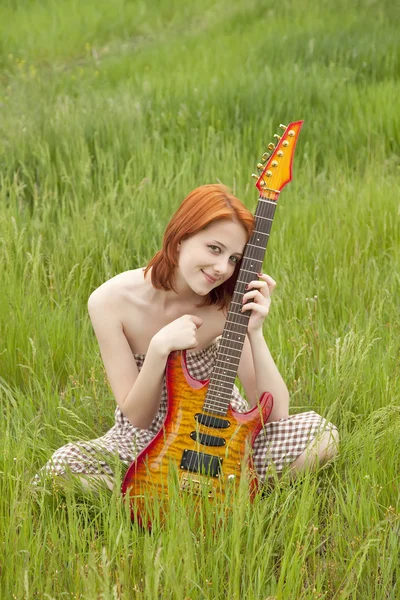 Dívka s kytarou v poli — Stock fotografie