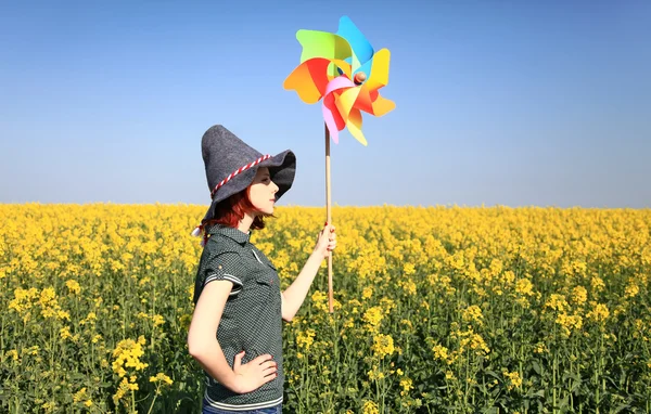 Unga trollkvinnan med vindkraftverk på rapsfält. — Stockfoto