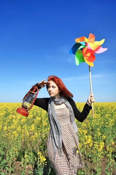 Jong meisje met windturbine en retro lamp bij verkrachting veld. — Stockfoto
