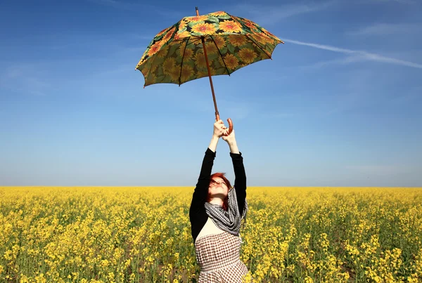 菜の花畑で傘を持つ若い女. — ストック写真