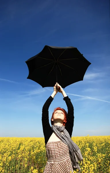 Young woman with umbrella at rape field. — Stock Photo, Image