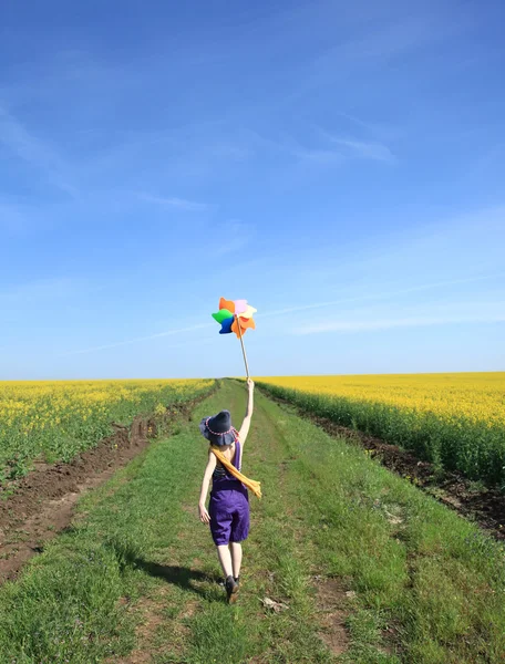 Młoda Czarodziejka z turbin wiatrowych na polu rzepaku. — Zdjęcie stockowe