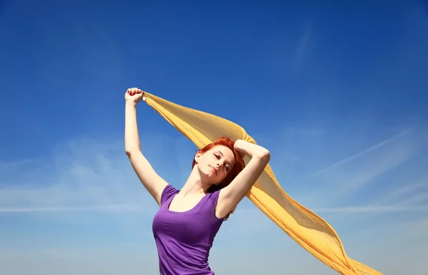 Νεαρή γυναίκα με ανοιχτές αγκάλες κρατήσει κίτρινο μετάξι με άνεμο. — Φωτογραφία Αρχείου