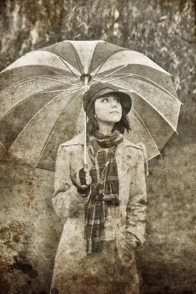 Girl with umbrella at park in rainy day. Photo in vintage style — Zdjęcie stockowe