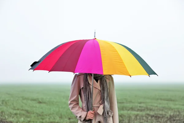 Meisje met paraplu op veld. — Stockfoto
