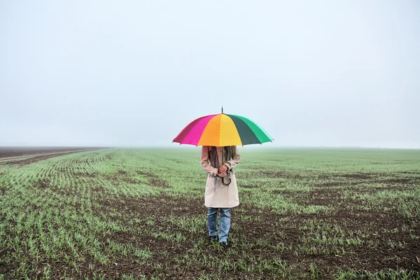 Girl with umbrella at field. — Stock Photo, Image