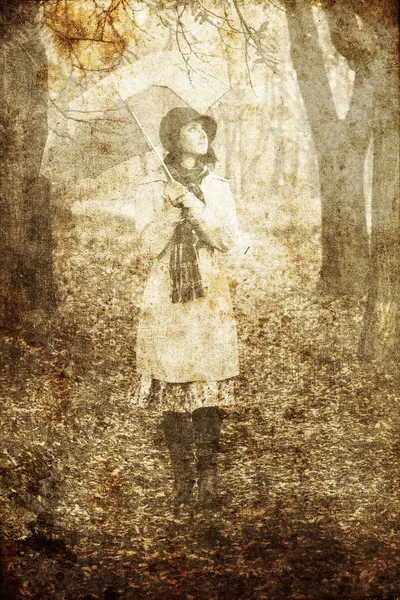 Chica de capa y bufanda con paraguas en el parque en días de lluvia. Foto en vintag —  Fotos de Stock