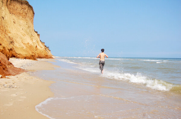 Boy running by beach