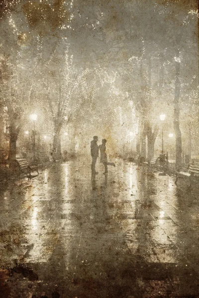 Couple walking at alley in night lights. Photo in vintage yellow style. — Stock Photo, Image