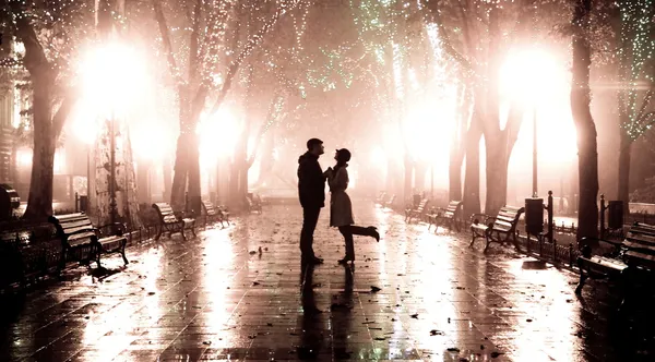 Um casal a andar no beco à noite. Foto em estilo vintage . — Fotografia de Stock