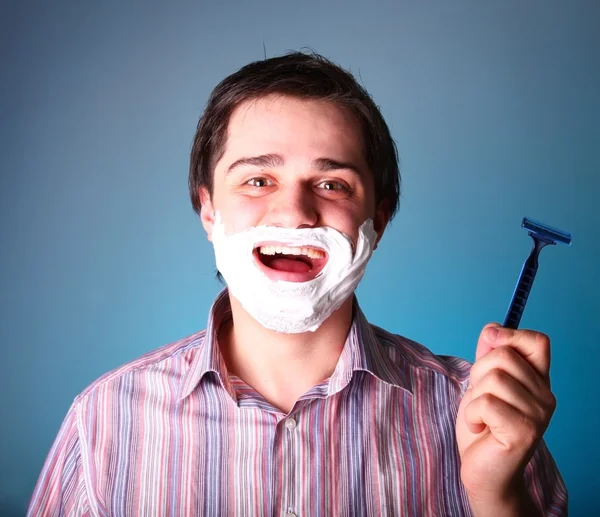 Человек бритья изолированы на голубом фоне — стоковое фото