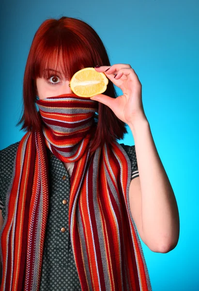 マフラーで寒さ女の子目の代わりにレモンを維持します。 — ストック写真