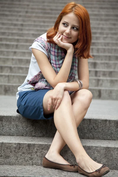 Portret van mooi roodharig meisje op voetstap. — Stockfoto