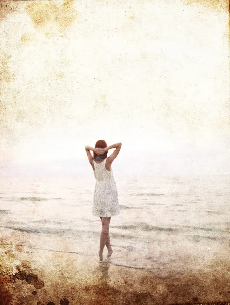 Krásná mladá dívka na pláži na východ slunce. Foto ve staré barvy obrazu chlívku — Stock fotografie