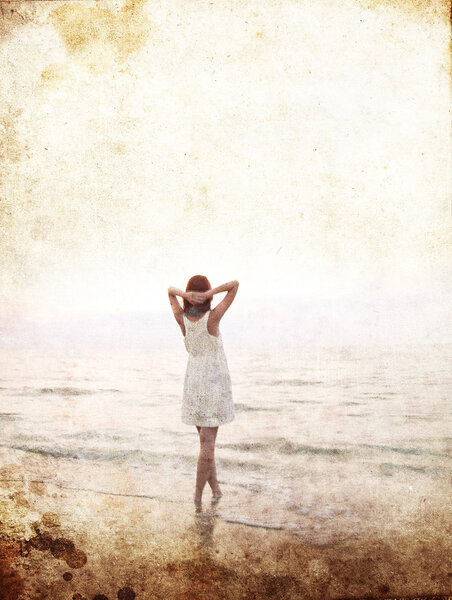 Young beautiful girl on the beach at sunrise. Photo in old colour image sty
