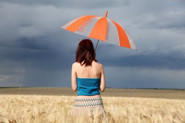yağmurlu bir gün alanında, şemsiye ile kız.