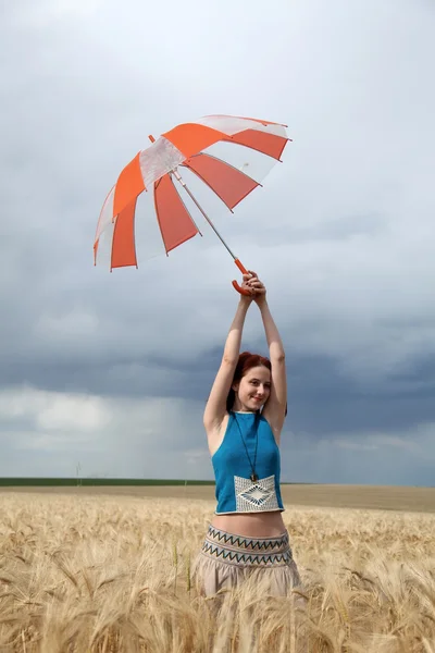 Dziewczyna z parasolem w polu w deszczowy dzień. — Zdjęcie stockowe
