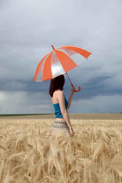 Dziewczyna z parasolem w polu w deszczowy dzień. — Zdjęcie stockowe