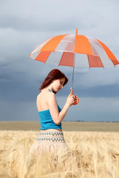 Mädchen mit Regenschirm auf Feld — Stockfoto