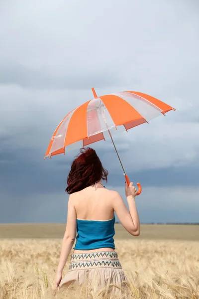 Menina com guarda-chuva no campo em dia chuvoso . — Fotografia de Stock